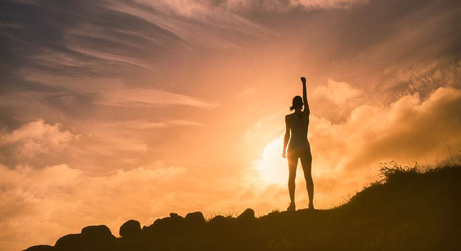 Woman on a mountain top at dawn