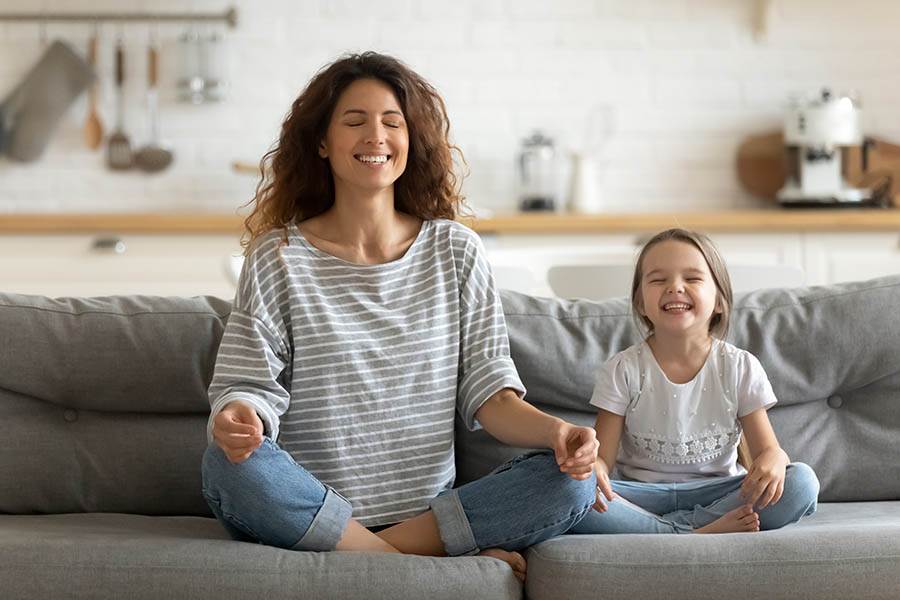 Mother and child meditating on the couch